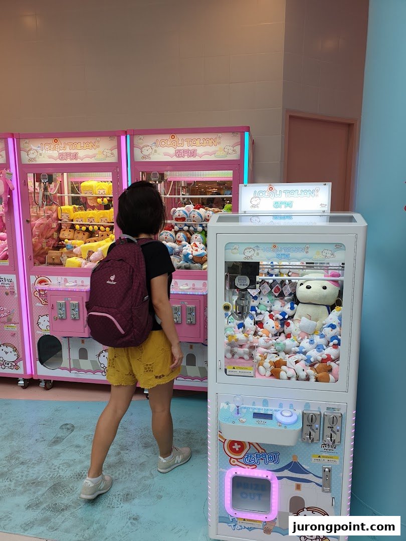 A person stands before colorful claw machines filled with various plush toys at iClaw Taiwan.