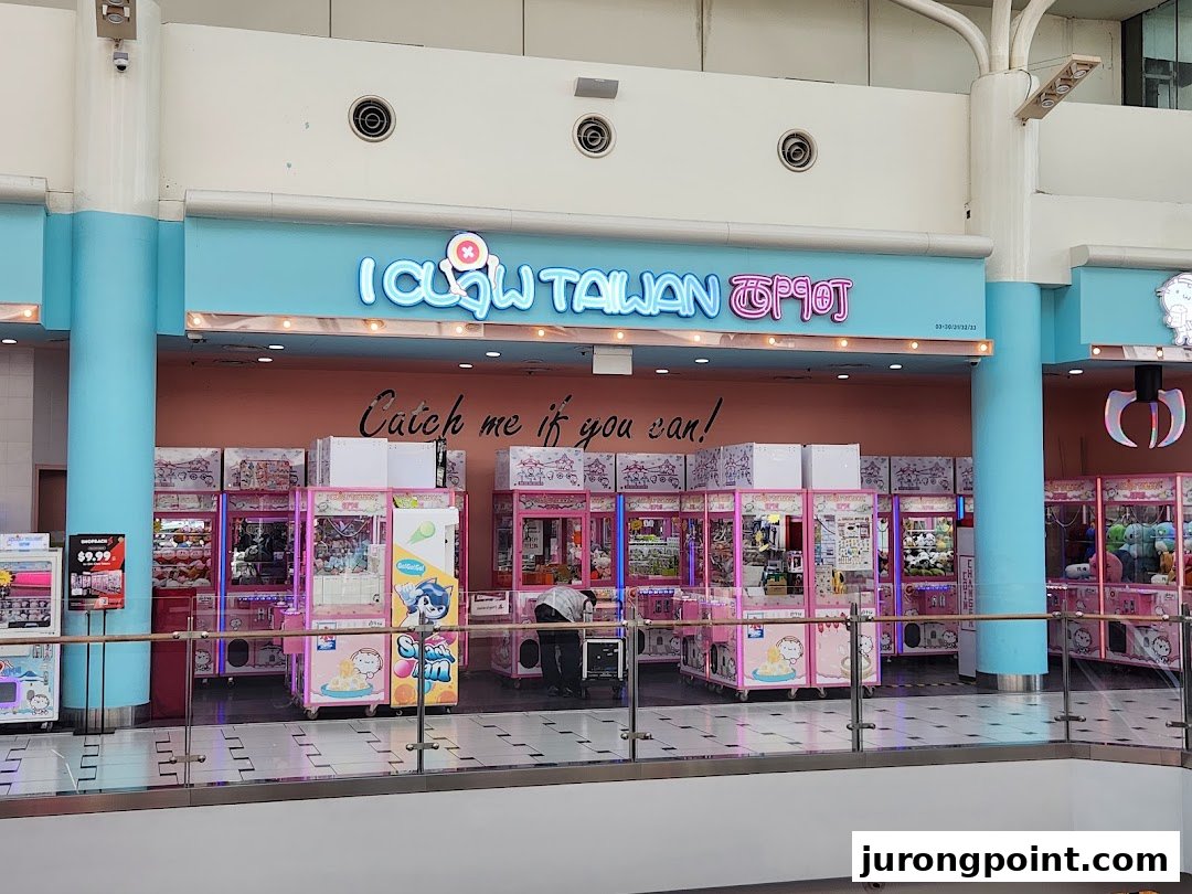 The vibrant entrance of iClaw Taiwan, a claw machine arcade, filled with numerous pink claw machines.