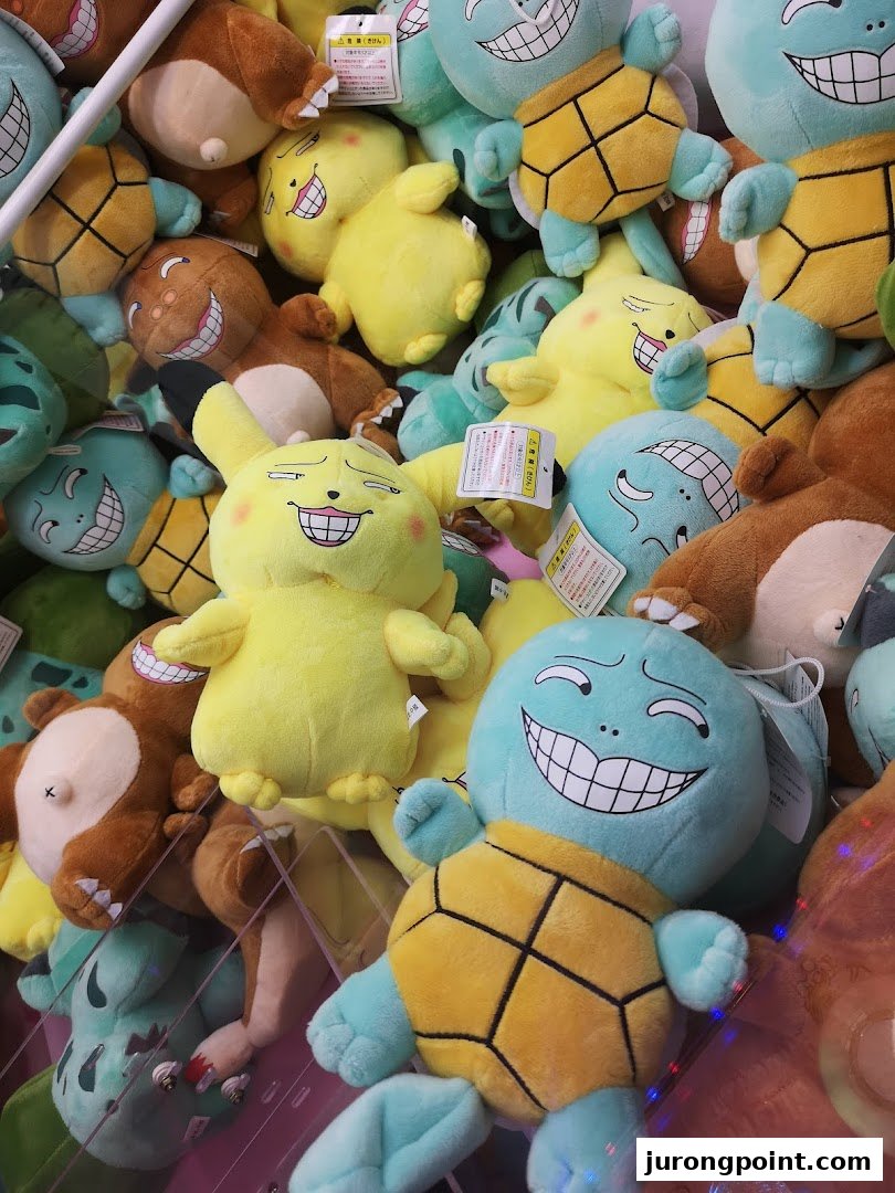 A vibrant collection of quirky plush toys, including turtles and yellow characters, inside a claw machine.