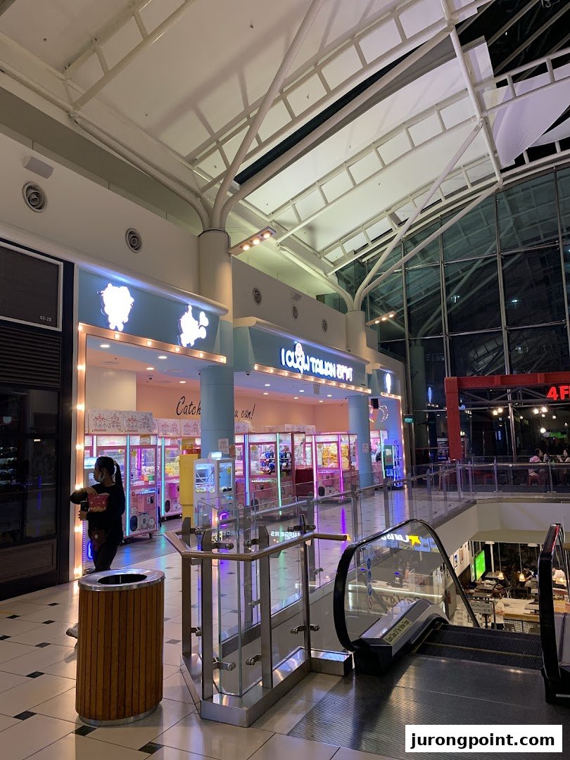 The brightly lit entrance of iClaw Taiwan, a claw machine arcade, within a shopping mall.