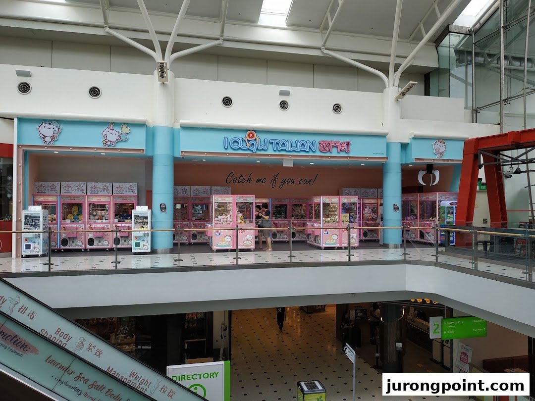 A vibrant iClaw Taiwan shop filled with numerous claw machines, seen from a mall's upper level.