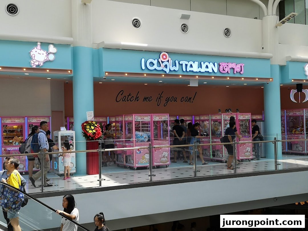 The iClaw Taiwan shop entrance features numerous pink claw machines, attracting visitors trying to win prizes.