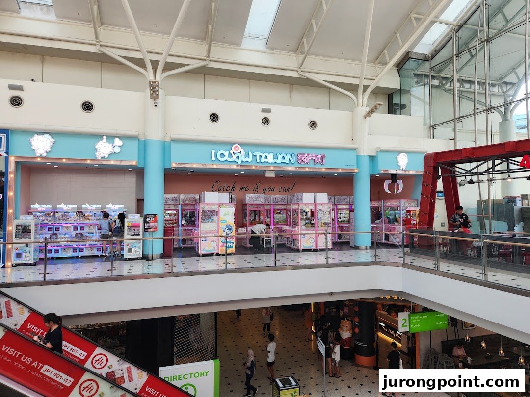 The vibrant iClaw Taiwan shop, filled with numerous claw machines, seen from a mall's upper level.