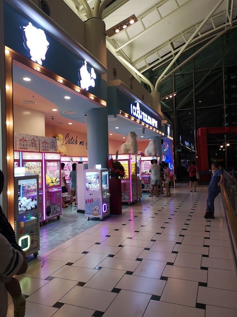 A brightly lit iClaw Taiwan shop entrance with multiple claw machines and people playing.
