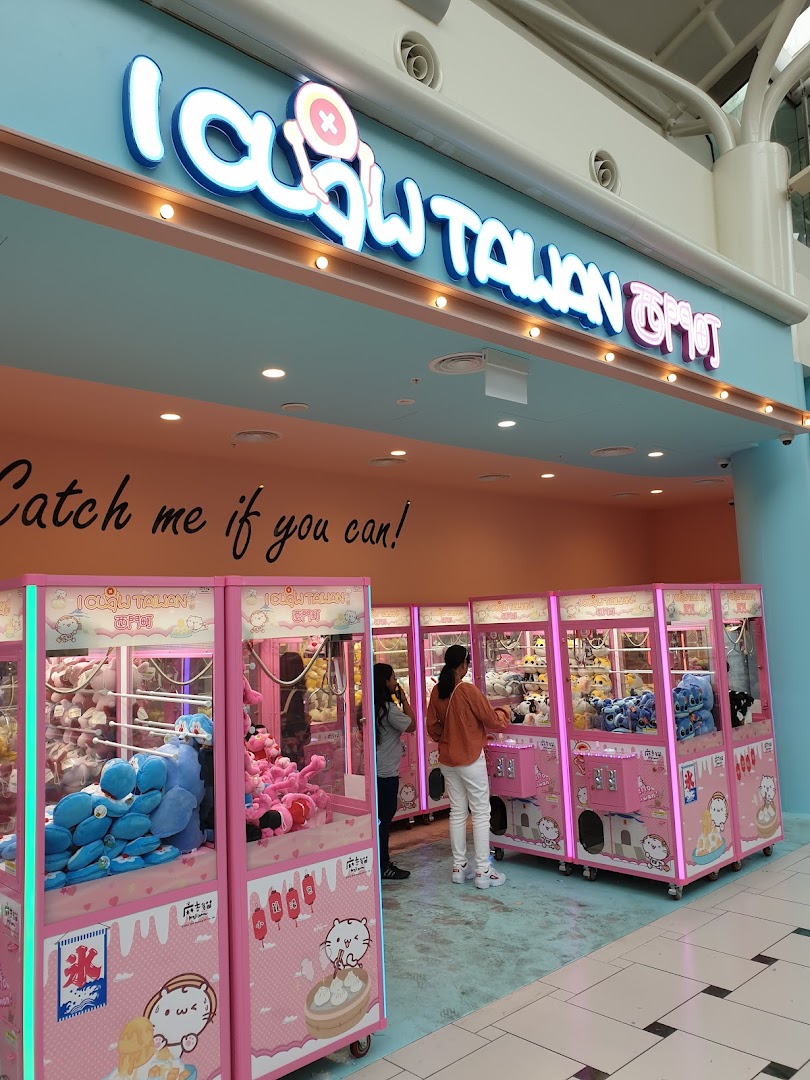 The vibrant pink entrance of iClaw Taiwan, featuring numerous claw machines and customers.