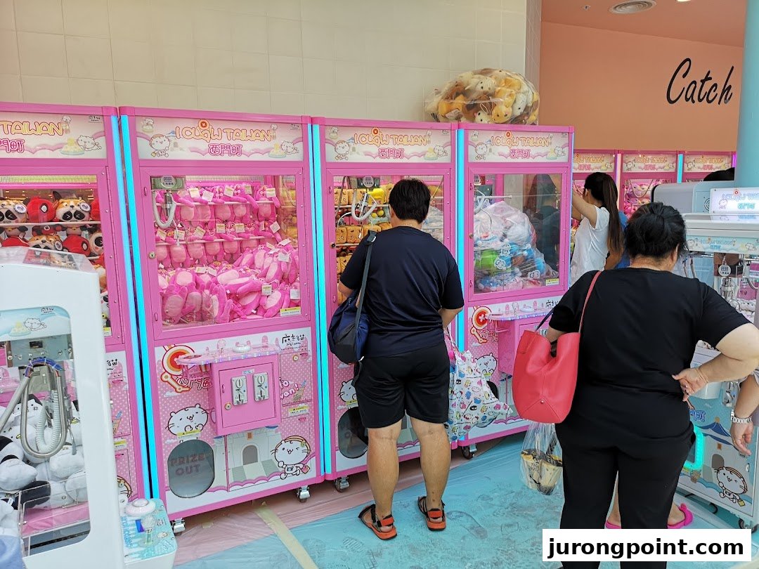 People playing colorful claw machines filled with plush toys at iClaw Taiwan.
