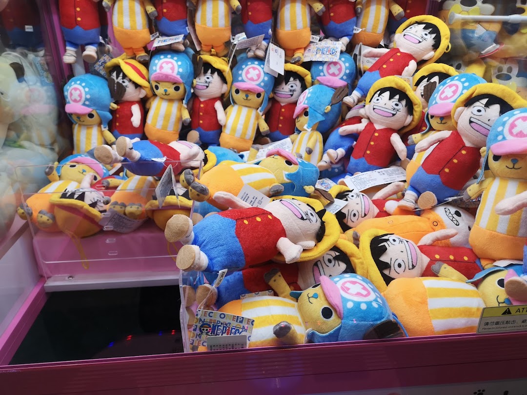 A claw machine filled with numerous One Piece character plush toys, including Luffy and Chopper.