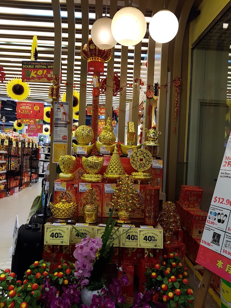 Festive golden decorations and artificial flowers displayed inside a Japan Home store, likely for Chinese New Year.