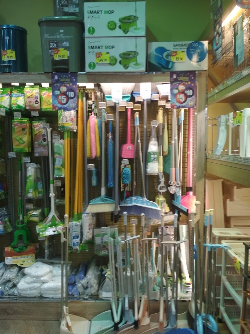 An aisle in Japan Home showcasing a wide variety of mops, brooms, and household cleaning tools.