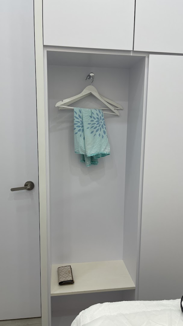 A clean, minimalist changing area with a hanger, patterned cloth, and a wallet.