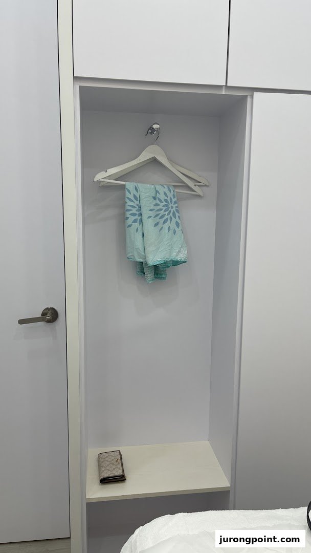 A clean, minimalist changing area with a hanger, patterned cloth, and a wallet.