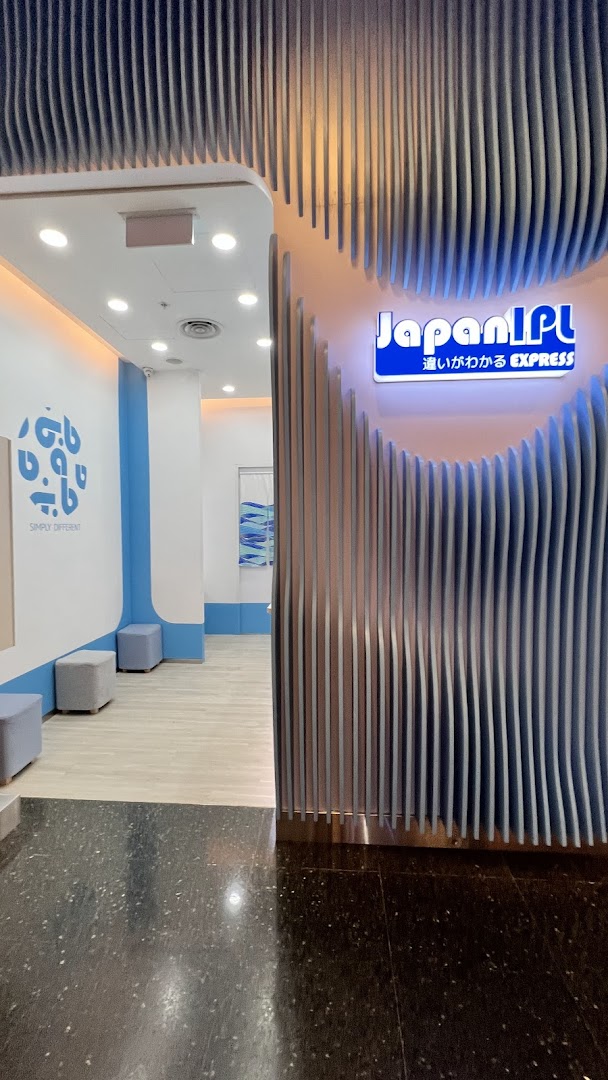 The entrance of Japan IPL Express features a modern blue and white design with a distinctive wavy facade.