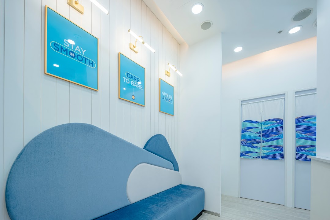 A modern, clean waiting area with a blue sofa and motivational artwork at Japan IPL Express.