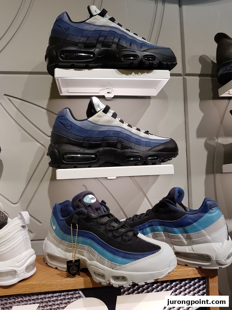 Close-up of various Nike Air Max sneakers displayed on shelves inside JD Sports.