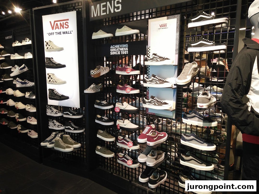 A vibrant display of Vans sneakers and other athletic footwear on shelves in a retail store.