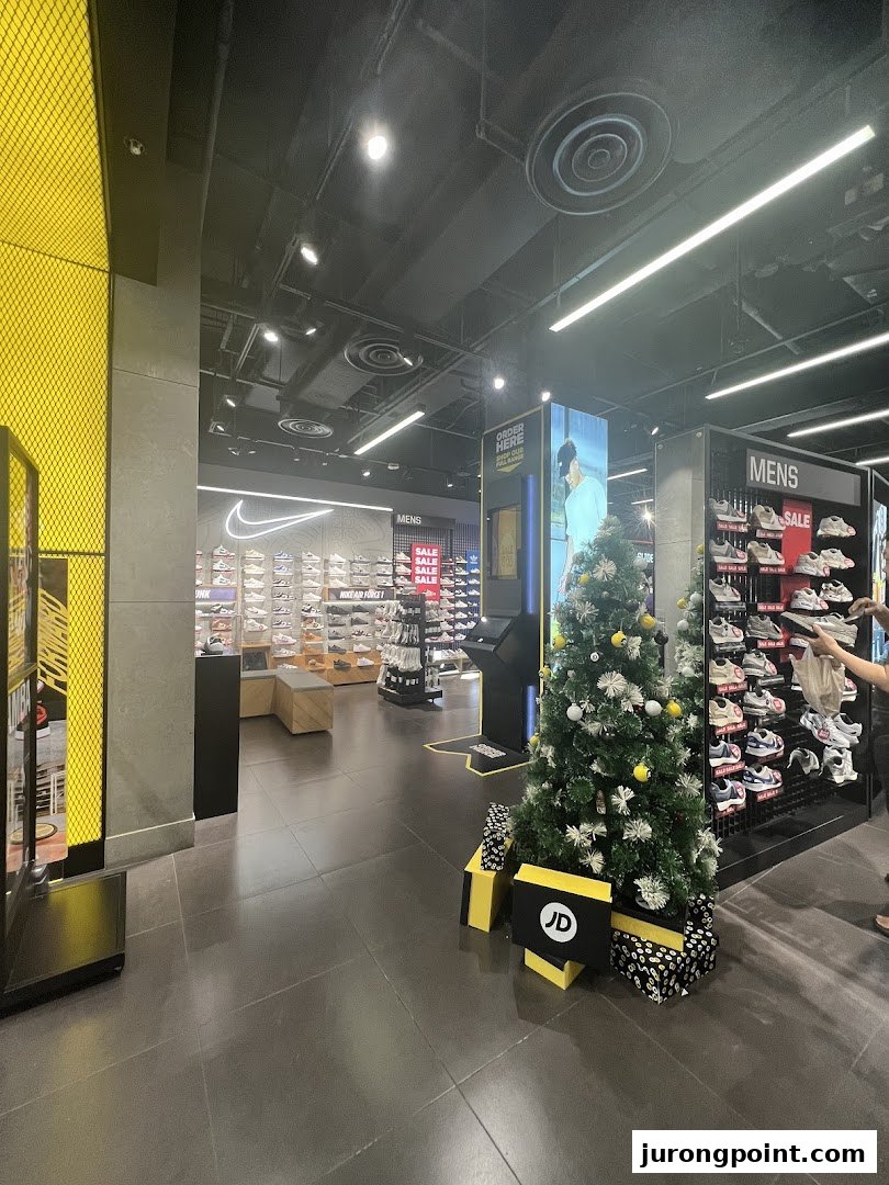 Interior view of JD Sports, showcasing footwear displays, a 'MENS' section, and festive Christmas decorations.