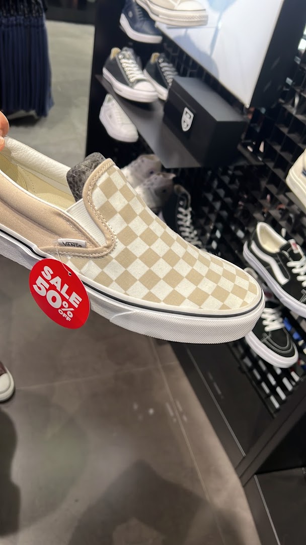 Close-up of a Vans shoe with a 50% off sale tag inside JD Sports.