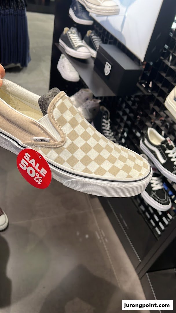 Close-up of a Vans shoe with a 50% off sale tag inside JD Sports.