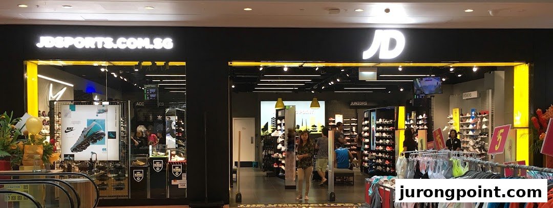 The shop front of JD Sports, featuring its prominent logo, entrance, and visible interior displays of sportswear.