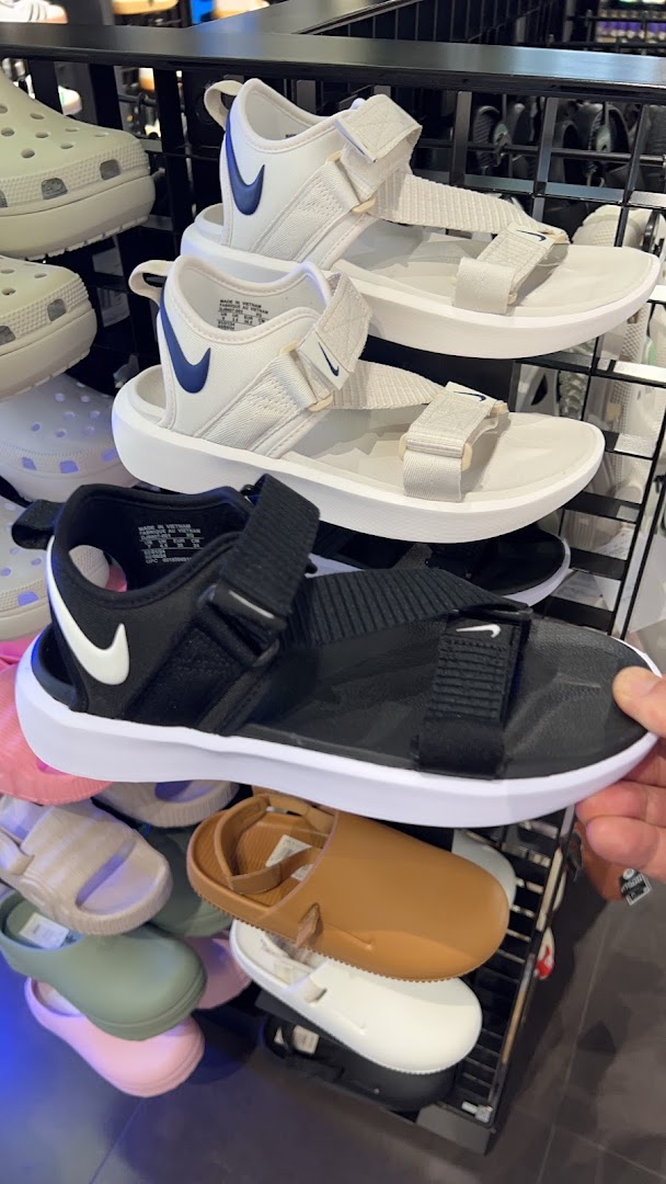 A display of Nike sandals and other casual footwear inside a JD Sports store.