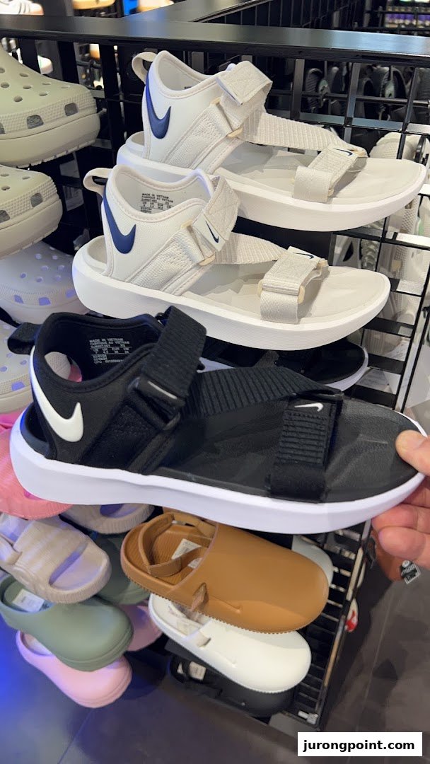 A display of Nike sandals and other casual footwear inside a JD Sports store.