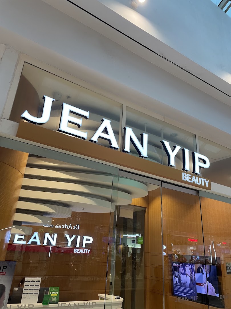 The illuminated storefront of Jean Yip Aesthetics, a beauty and hair salon.