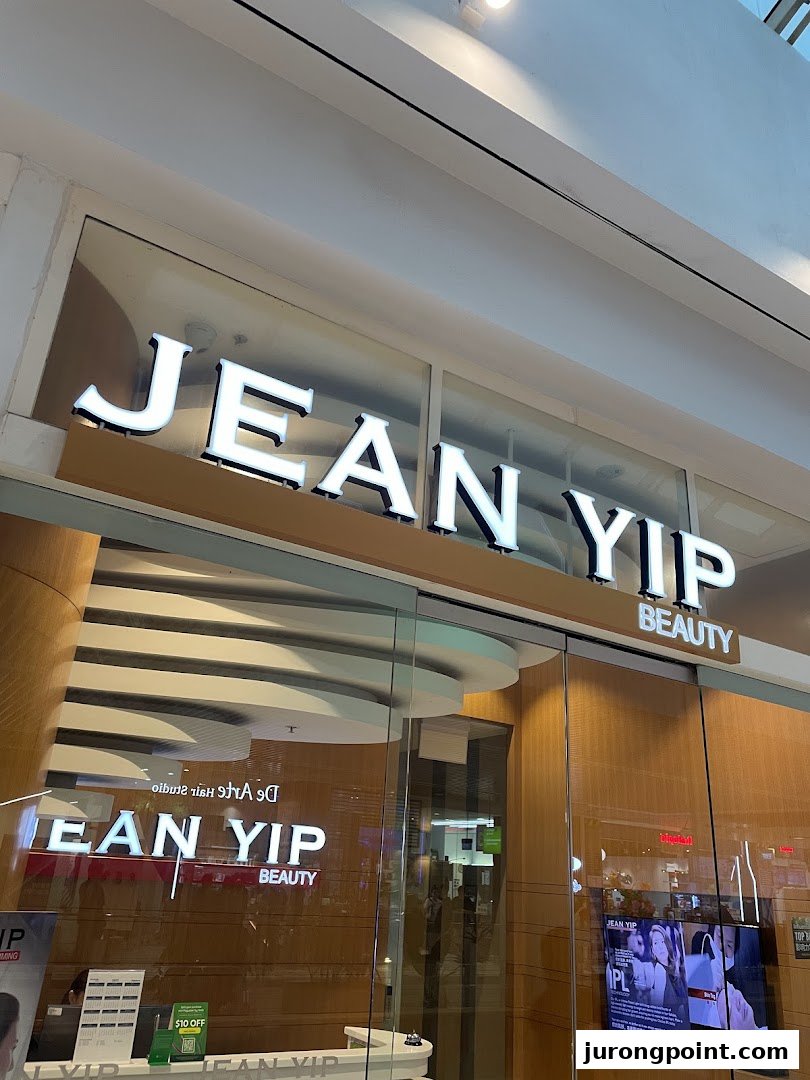 The illuminated storefront of Jean Yip Aesthetics, a beauty and hair salon.