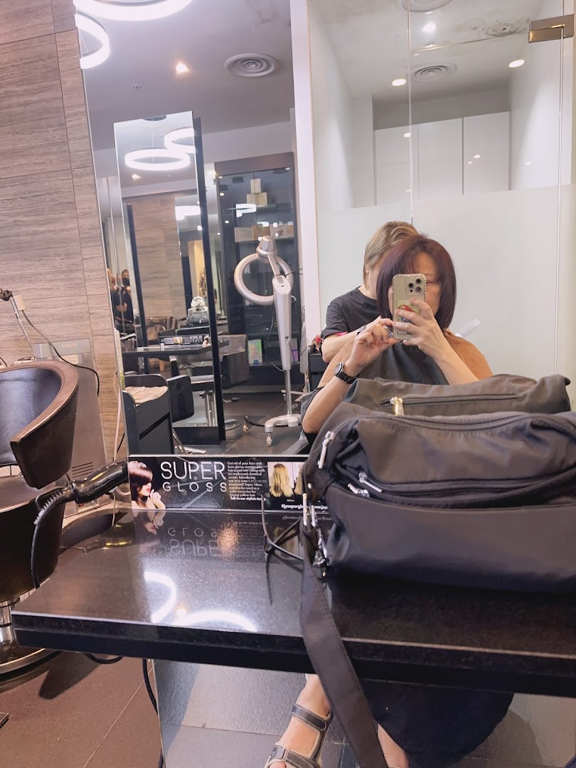 A customer receives a hair treatment in a modern salon setting at Jean Yip Aesthetics.