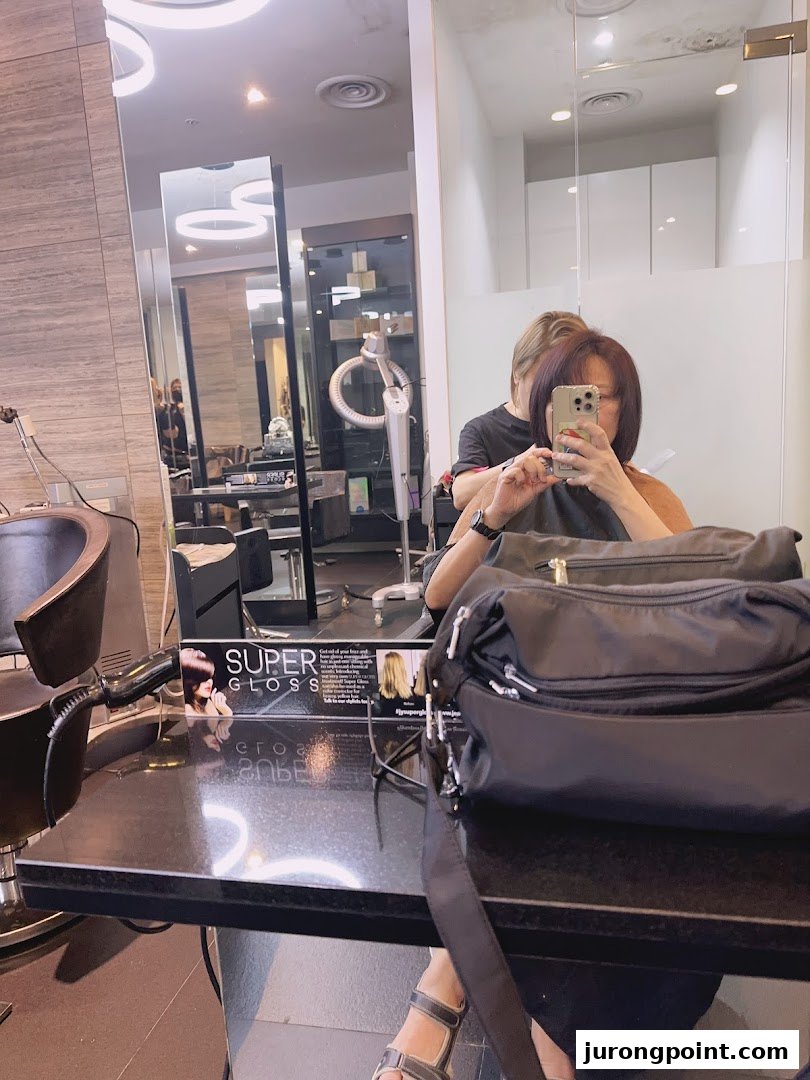 A customer receives a hair treatment in a modern salon setting at Jean Yip Aesthetics.
