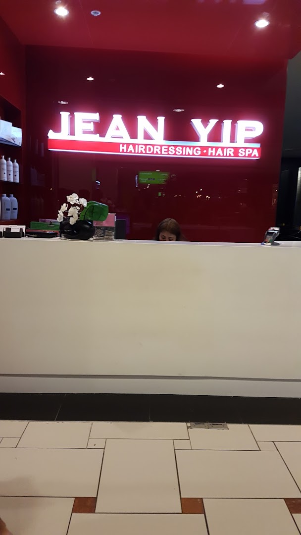 Interior shot of Jean Yip Aesthetics reception area with a prominent illuminated sign and desk.