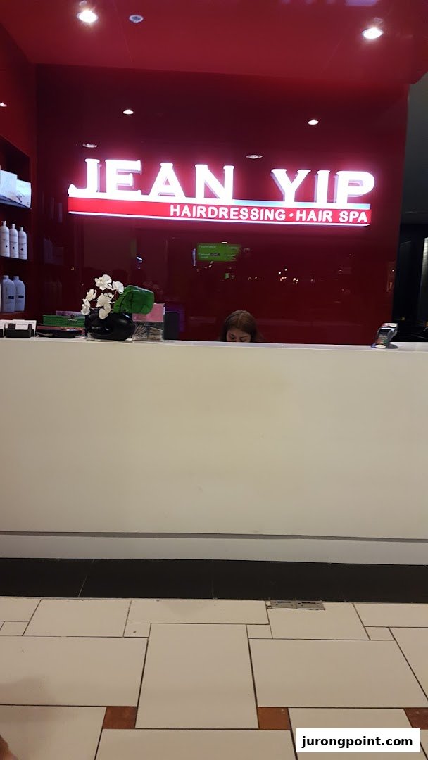 Interior shot of Jean Yip Aesthetics reception area with a prominent illuminated sign and desk.
