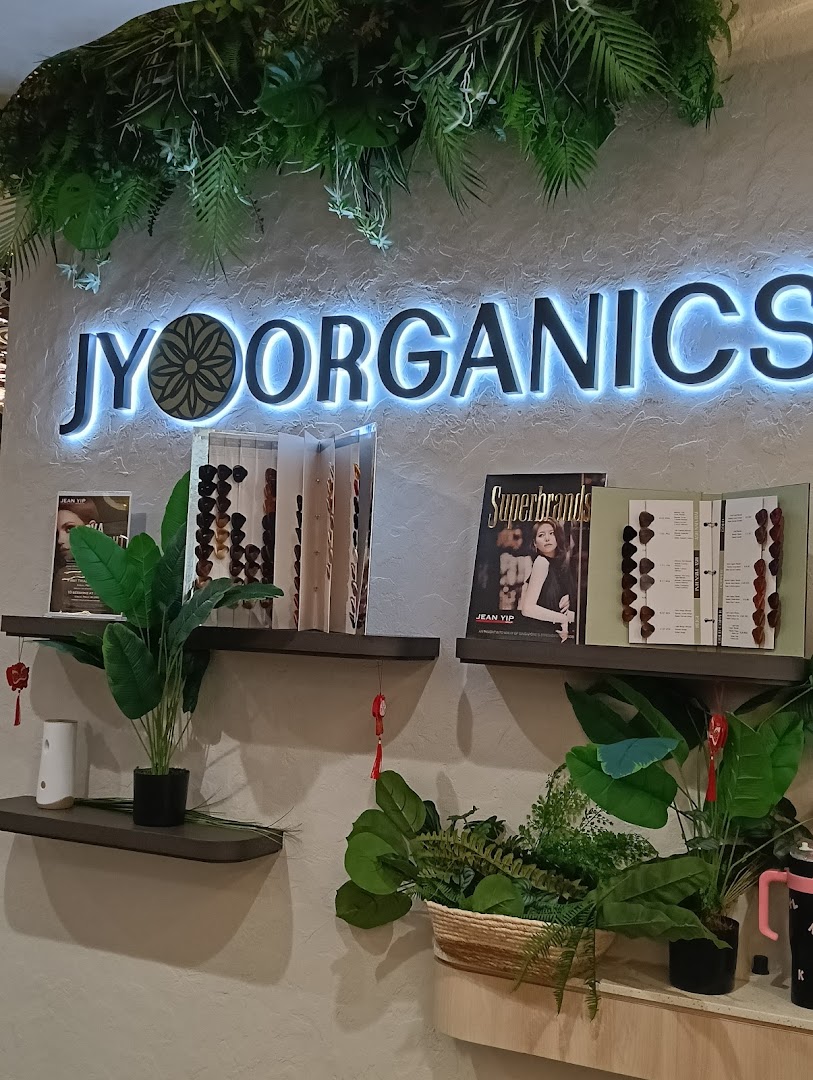 Interior view of Jean Yip Hairdressing showcasing the 'JY ORGANICS' section with plants and product displays.
