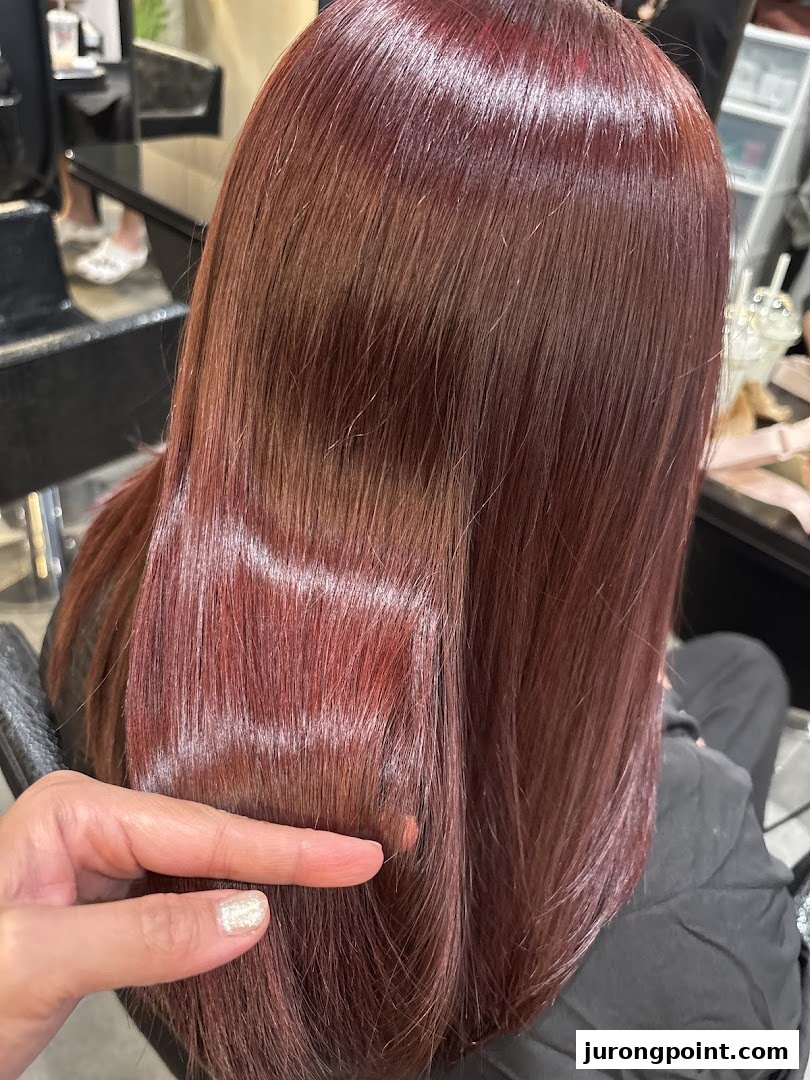 Close-up of a person's long, reddish-brown hair, showcasing its smooth texture and vibrant color.