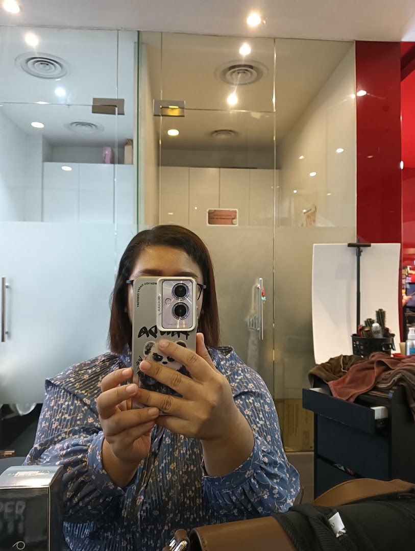 A person taking a selfie inside Jean Yip Hairdressing, showing the salon's interior with mirrors and equipment.