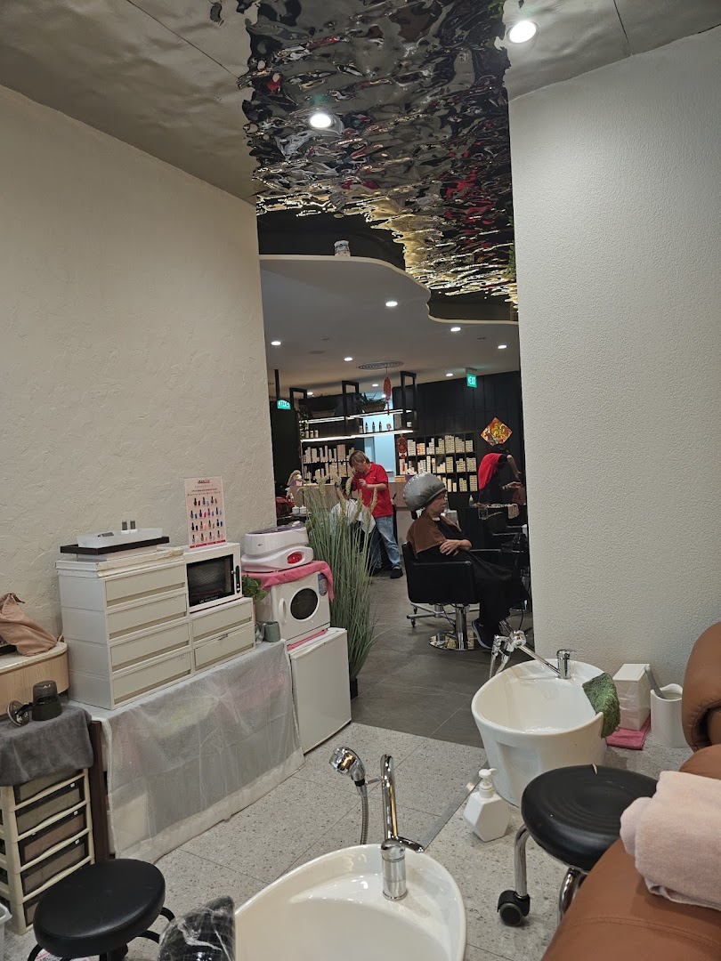 Interior view of Jean Yip Hairdressing, showing styling stations, a pedicure area, and clients.