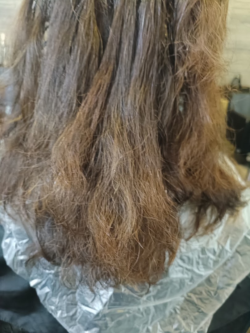 Close-up of hair undergoing a treatment, likely coloring or perming, at a salon.