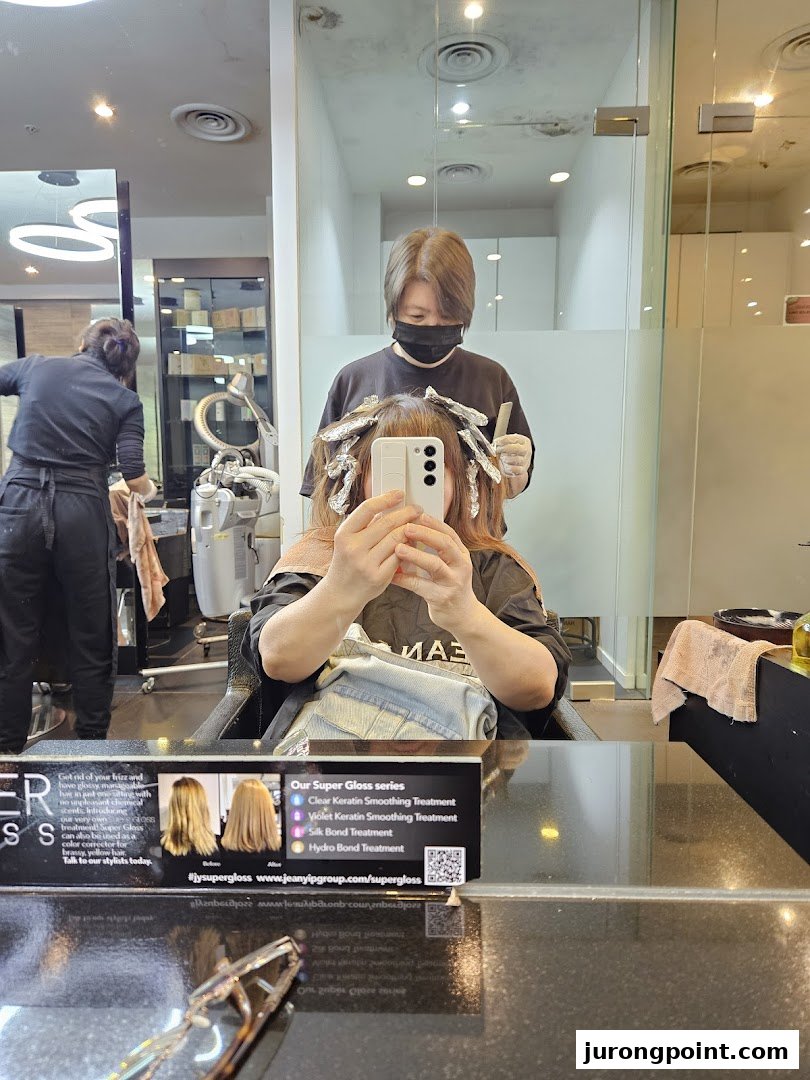 Customer receiving a hair treatment with foils from a stylist in a modern salon setting.