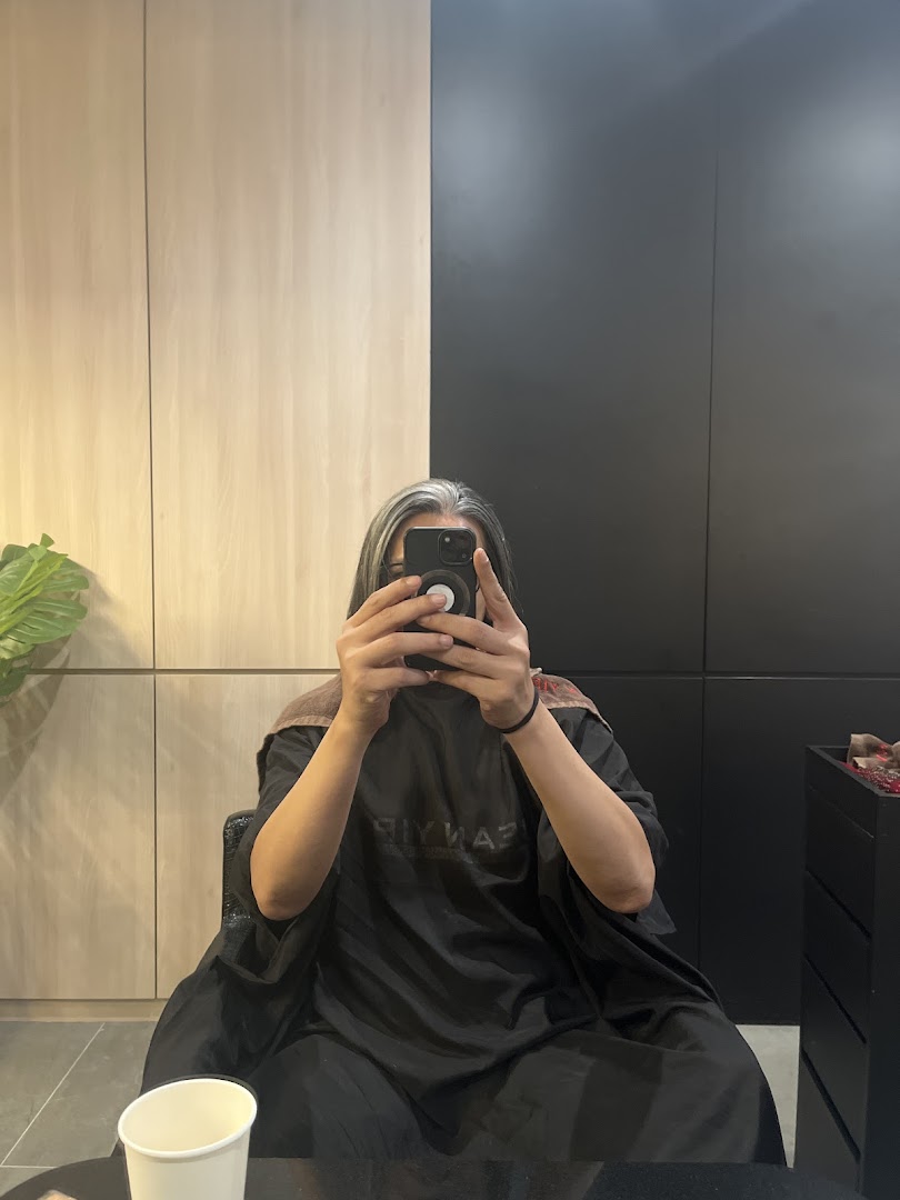 A client takes a mirror selfie inside Jean Yip Hairdressing, showcasing the salon's modern interior.