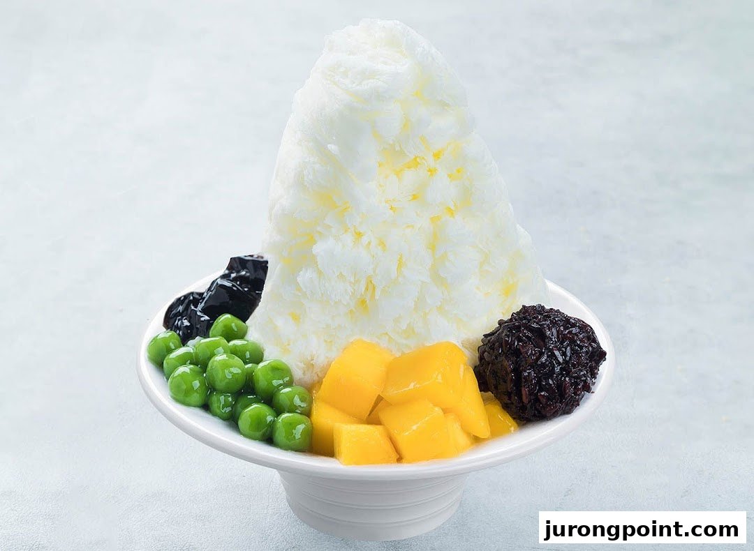 A vibrant shaved ice dessert with mango, green pearls, grass jelly, and black glutinous rice.