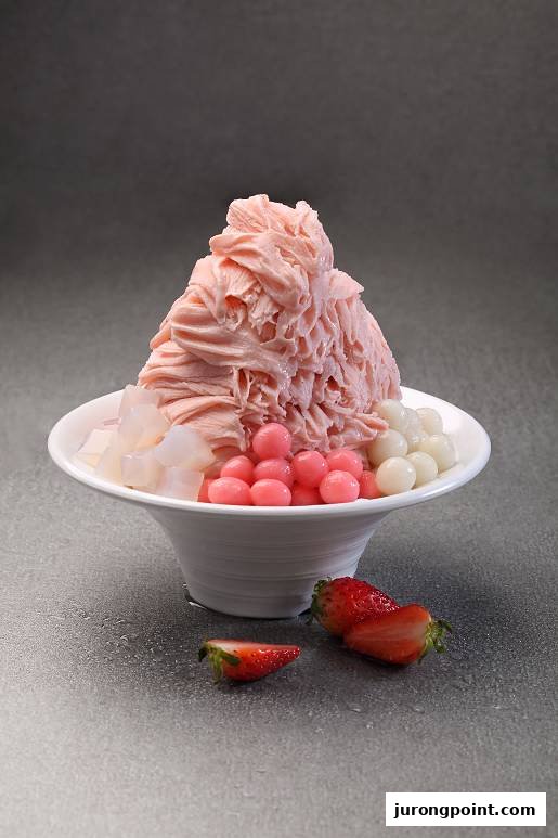 A vibrant bowl of pink shaved ice dessert with various toppings and fresh strawberries.