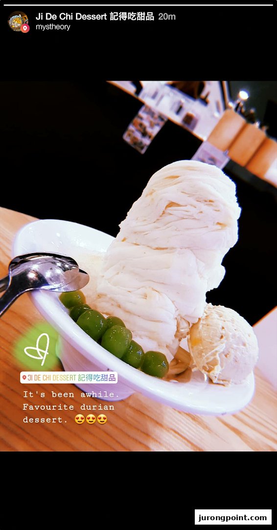 A close-up of a durian shaved ice dessert with green pearls and a scoop of ice cream.