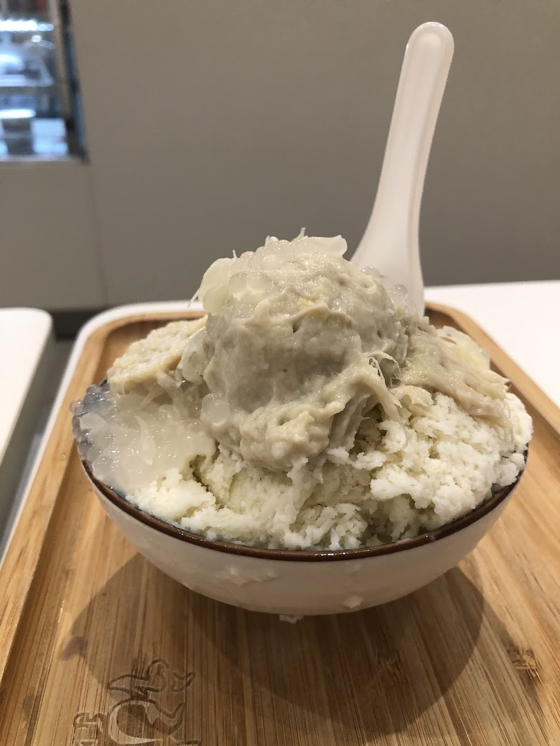 A close-up of a refreshing durian-flavored shaved ice dessert with toppings in a bowl.