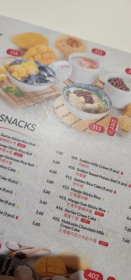 A close-up view of Ji De Chi Dessert's menu, showcasing various snacks and desserts with prices.