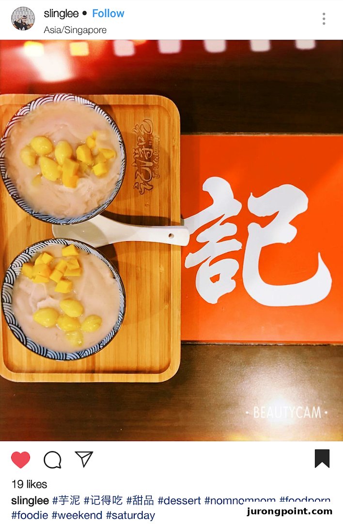 Two bowls of taro dessert with ginkgo nuts and mango cubes on a wooden tray.