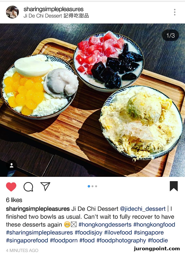 Three vibrant bowls of Asian desserts, including shaved ice and fruit, served on a wooden tray.