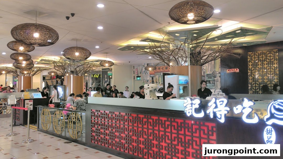 Interior view of Ji De Chi Dessert, featuring a vibrant counter, traditional decor, and customers enjoying treats.