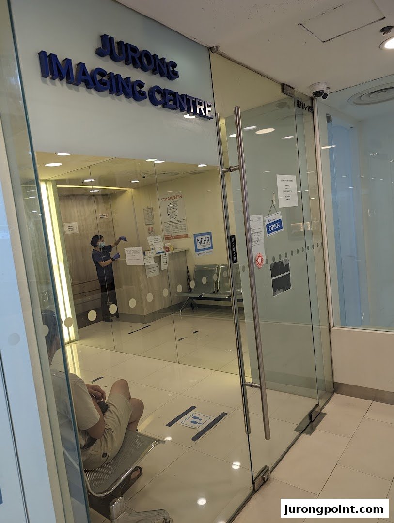 The glass entrance of Jurong Imaging Centre, showing a waiting area and a staff member inside.