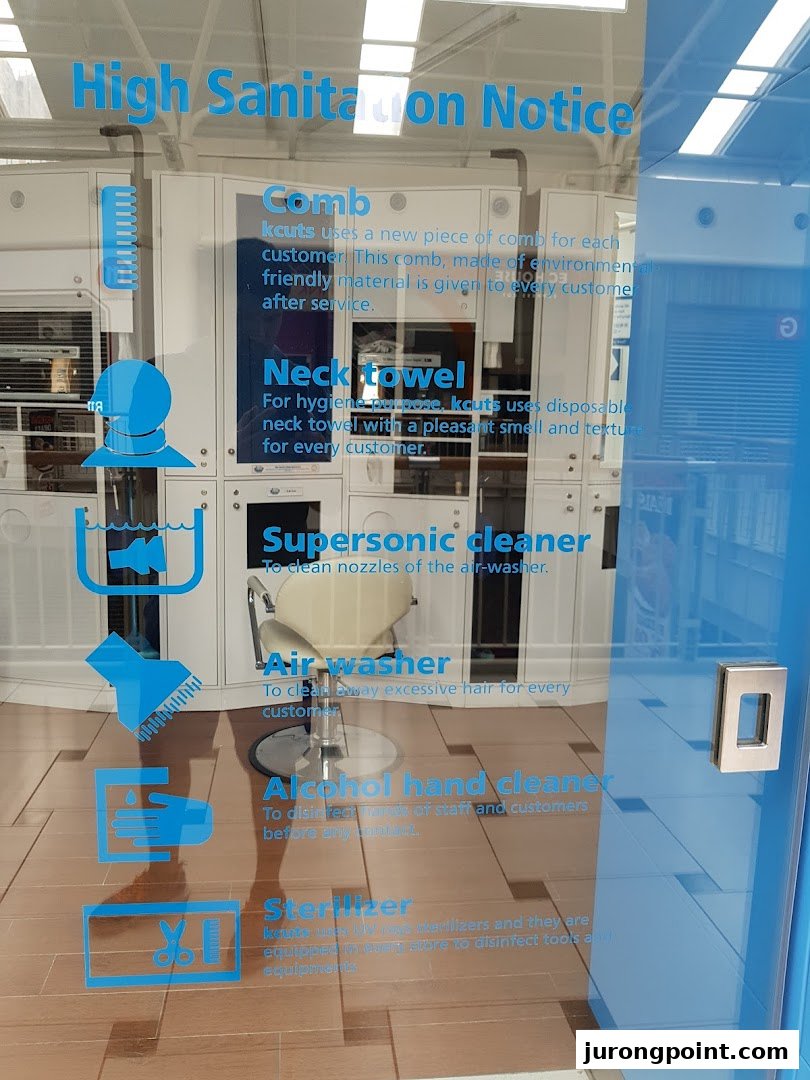 An interior view of kcuts hair salon through a glass door displaying a high sanitation notice.