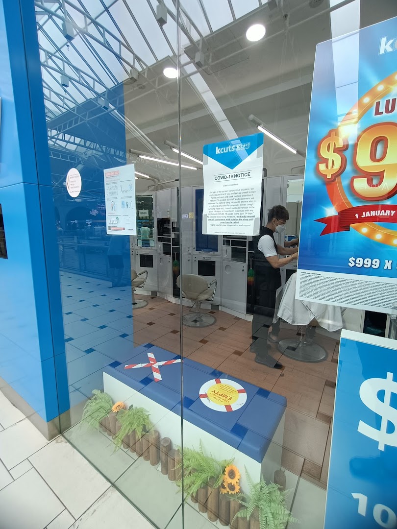 The kcuts shop entrance features a staff member inside, visible through the glass facade.
