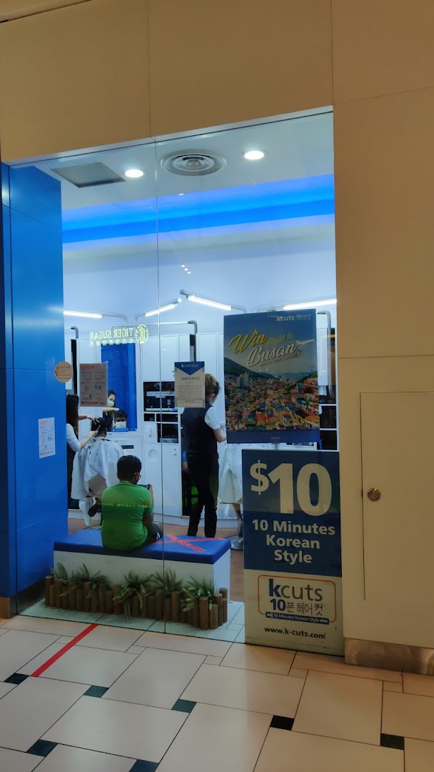 The kcuts shop front features a blue and white design, with customers inside and promotional signage.